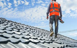 A roofer inspecting a metal shingle roof