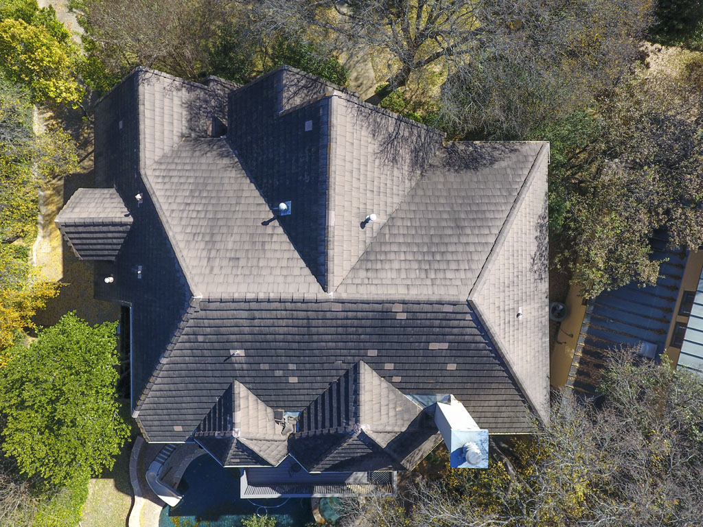 Before image of a buckskin metal roof replacement that shows a old weathered traditional shingle roof